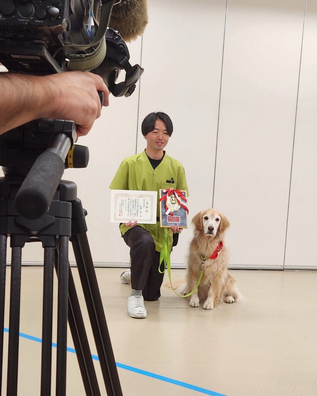 全国大会トロフィーと賞状を持ってインタビューを受けている様子