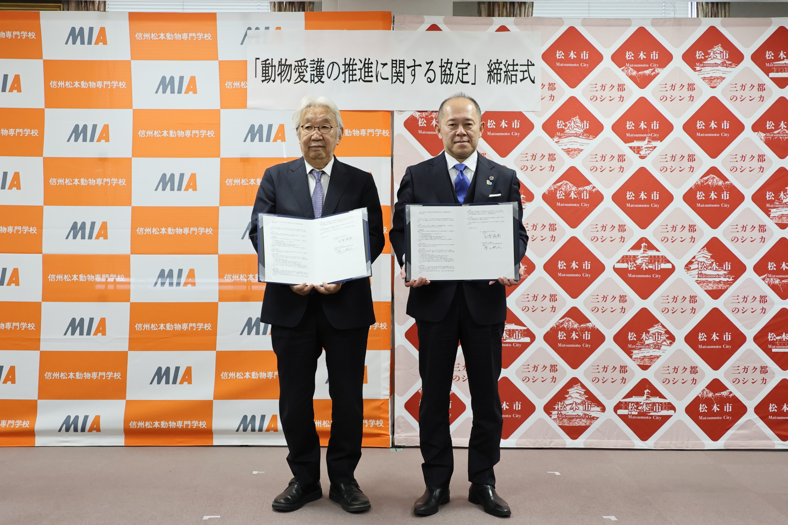 締結書を掲げて写真撮影をしている様子